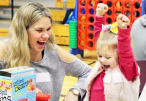 Mom and young daughter celebrate a win at Game Night at CID.