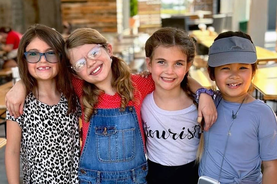 four smiling girls who are friends